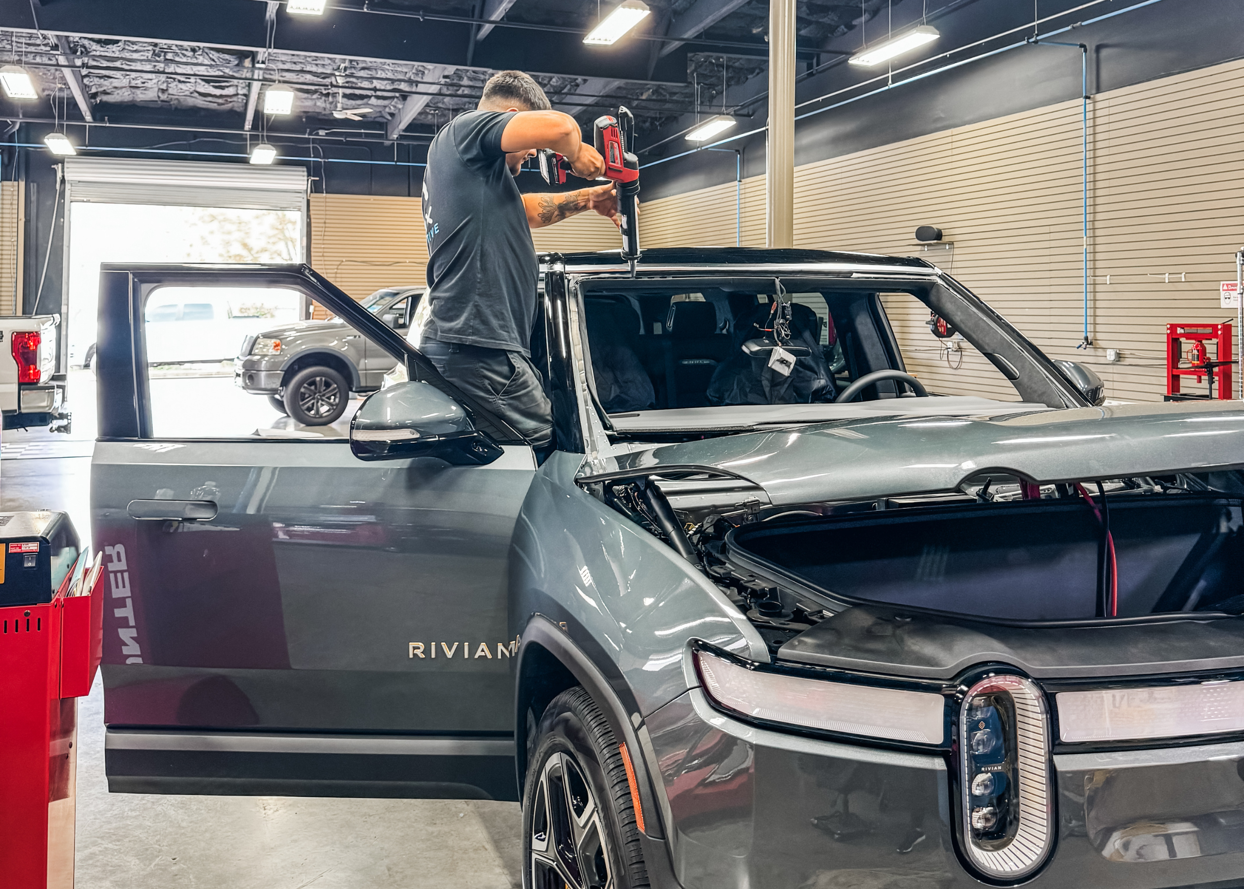 a technician performing a windshield replacement on a rivian vehicle in rocklin
